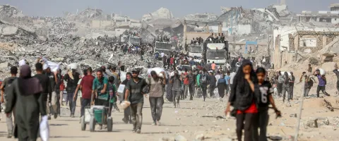 Imagen de personas desplazadas en Gaza transportando harina y ayuda alimentaria