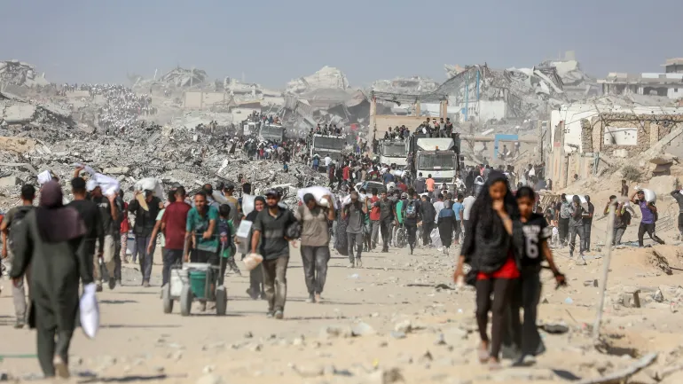 Imagen de personas desplazadas en Gaza transportando harina y ayuda alimentaria