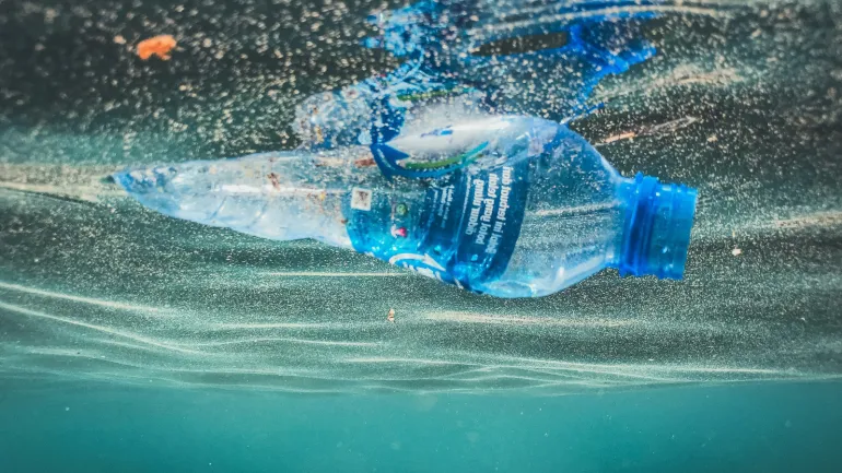 Botella de plástico flotando en el mar