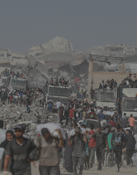 Imagen de personas desplazadas en Gaza transportando harina y ayuda alimentaria